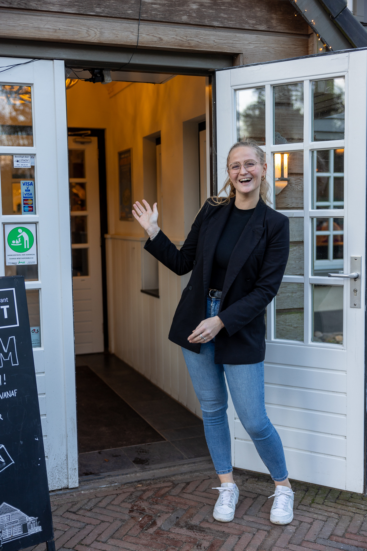 bedieningsmedewerker alana lacht en staat op het terras