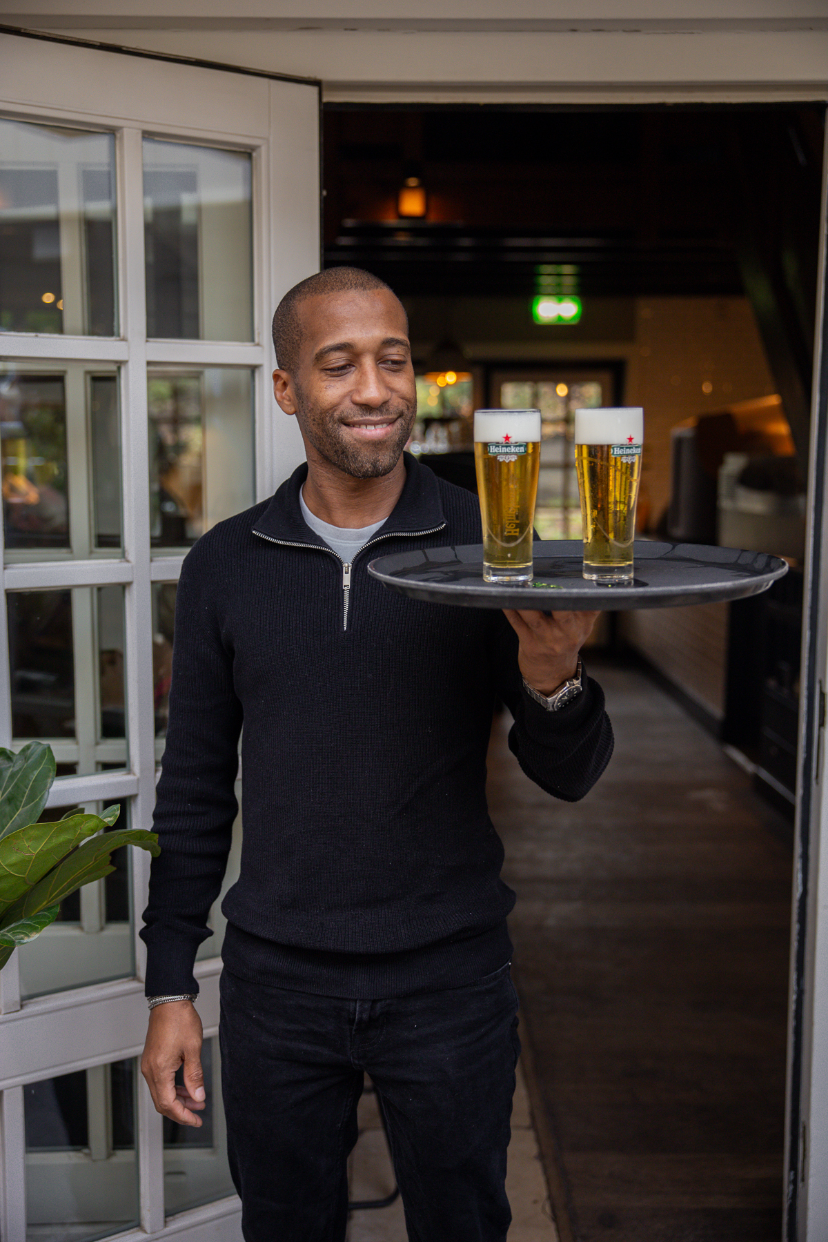 bedieningsmedewerker alana lacht en staat op het terras